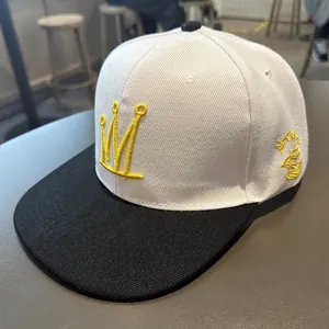 Détail de la broderie couronne jaune sur casquette snapback bicolore noir et blanc