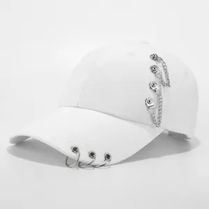 Detail der weißen Baumwoll-Baseballkappe mit silbernen Ringen und Metallkettenverzierung
