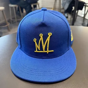 Casquette hip-hop couronne bleu roi avec broderie jaune sur une surface lisse