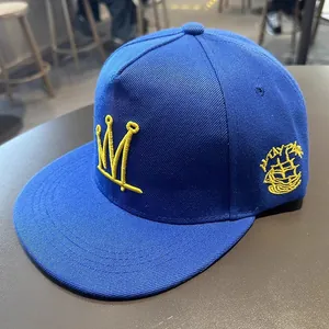 Casquette hip-hop bleue à bord plat avec broderie couronne jaune et patch latéral
