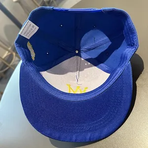 Détails intérieurs de la casquette bleue en coton avec broderie couronne et étiquette