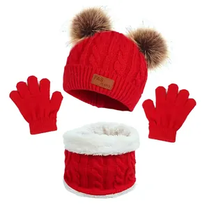 Detail of red cable knit winter set featuring faux fur pom-poms and warm fleece lining
