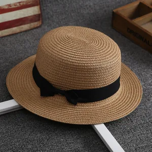 Flat top straw boater hat in light brown weave with a black ribbon bow decoration