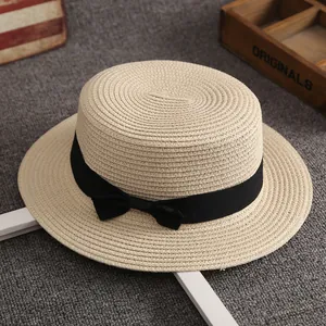 Classic beige flat top boater hat with black ribbon and bow for summer beach sun protection