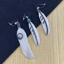 Détail de pendentifs plumes avec touches de turquoise, perle et diamant noir
