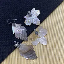 Détails de pendentifs en nacre naturelle en forme d'aile avec un éclat irisé et des perles