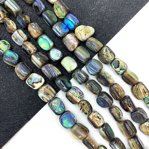 Gros plan de perles rectangulaires en nacre d'abalone aux reflets irisés et couleurs naturelles