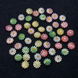 Macro shot of colorful daisy flower shell beads in pink, yellow, and green for DIY jewelry