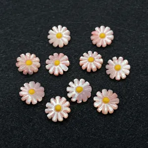 Detailed view of pink shell-like daisy beads with yellow center for DIY jewelry