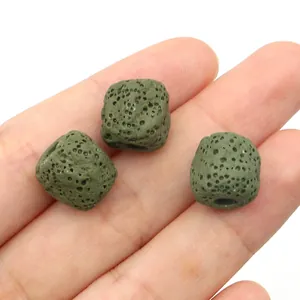 Vue rapprochée de trois perles cubiques en lave vert olive avec une texture poreuse