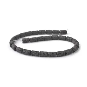 Macro detail of natural black lava rock cylinder beads with porous texture for DIY jewelry