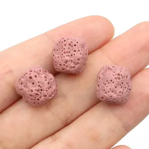 Gros plan de perles en pierre de lave rose pour bijoux diffuseurs d'huiles essentielles