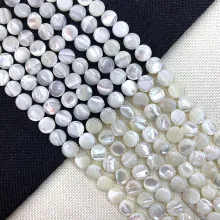 Macro shot of natural white shell flat round beads with iridescent luster for DIY jewelry