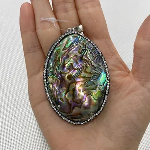 Makroaufnahme von ovalem Abalone-Muschel-Anhänger mit funkelnder Pavé-Einfassung