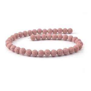 Dettaglio macro di perle di pietra lavica rosa naturale con finitura opaca testurizzata