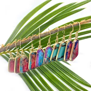Multicolor natural stone earrings with gold plated frames hanging on wooden branches