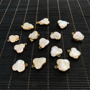 Detailed view of irregular baroque pearl pendants with gold edges on a bamboo mat