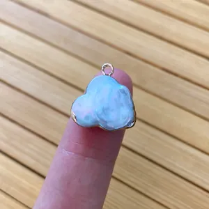 Macro detail of cloud shaped pearl pendant with golden metallic border for DIY jewelry