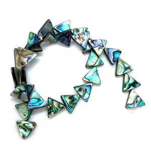 Gros plan de perles triangulaires en nacre d'abalone irisées pour bijoux DIY