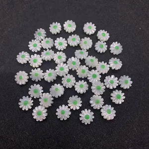 Detailed macro shot of white shell daisy beads with green center for DIY jewelry
