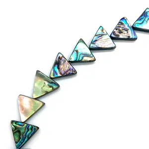 Détail macro de perles en nacre d'abalone triangulaires avec des reflets irisés colorés