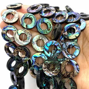Detailopname van cirkelvormige abalone schelpkralen met natuurlijke glans voor DIY-sieraden