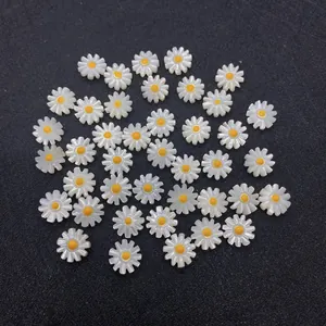 Macro detail of white daisy shell beads with yellow core for DIY jewelry making