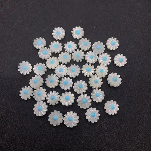 Macro shot of 10mm white mother of pearl daisy beads with blue centers for jewelry making