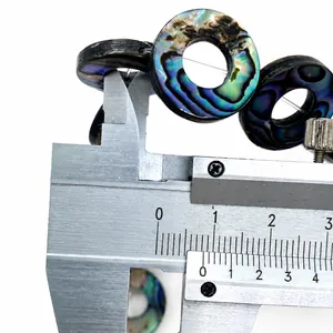 Macro-opname van natuurlijke abalone schelperingkraal gemeten met een digitale schuifmaat