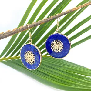 Bohemian gold Lapis Lazuli earrings with hollow mandala pattern hanging on a branch