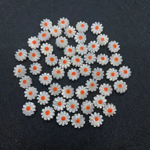 Macro shot of 10-12mm white shell daisy flower beads with orange center for DIY jewelry