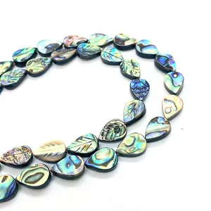 Vue détaillée de perles en nacre d'abalone en forme de feuille avec nervures gravées pour bijoux