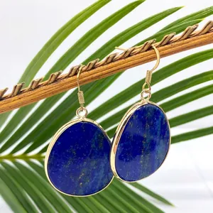Detailed close-up of blue lapis lazuli teardrop earrings with gold plated edge and hooks