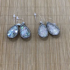 Détail macro de pendentifs goutte en nacre d'abalone avec strass et bélière
