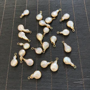 Macro detail of natural baroque pearl pendants with gold plated edges and loops
