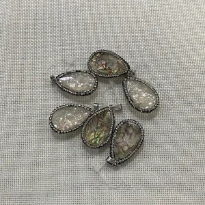 Détails de pendentifs en nacre d'abalone en forme de goutte avec cristaux sur tissu gris