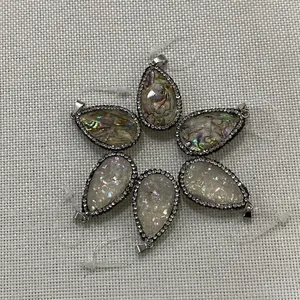 Détails macro de pendentifs goutte en nacre d'abalone avec strass et cadres argentés