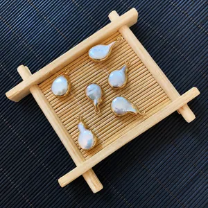 Close-up of irregular freshwater pearl pendants with gold-plated edges on a bamboo mat