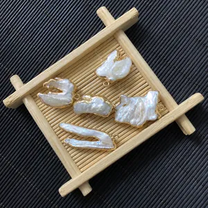Detalle de colgantes de perlas barrocas de agua dulce con bordes dorados y anillas de metal