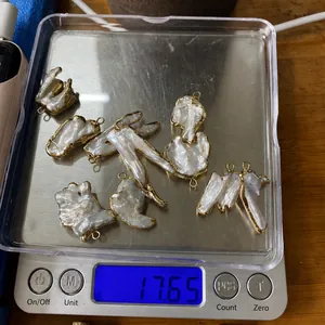 Ocho colgantes de perlas barrocas blancas que muestran un peso de 17,65 g en una báscula