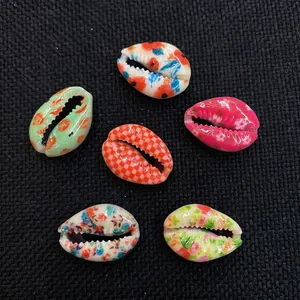 Makroaufnahme von 6 bedruckten Kauri-Muscheln mit Blumenmustern für DIY-Schmuckzubehör