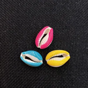 Detailed view of colorful cowrie shell beads in pink blue and yellow for DIY jewelry