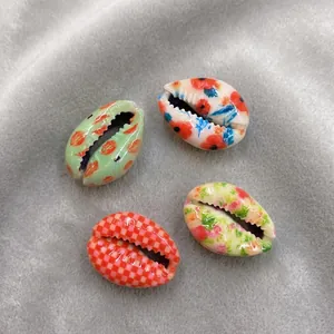 Nahaufnahme bunter floraler und karierter Muschelperlen für DIY-Schmuck aus Naturmaterial
