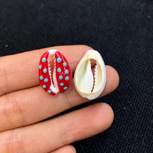 Close-up of small red shell bead with blue dots and white shell for DIY jewelry making