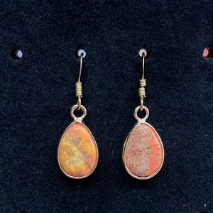 Waterdrop natural stone earrings with orange imperial jasper and gold hooks on black background