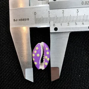 Detail showing caliper measurement of 1.5cm for purple shell bead with yellow dots