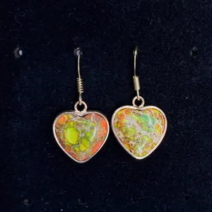 Bohemian heart-shaped imperial stone drop earrings with golden frames on black background