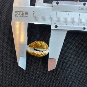 Detailed view of a 15mm shell bead with gold glitter measured by a caliper