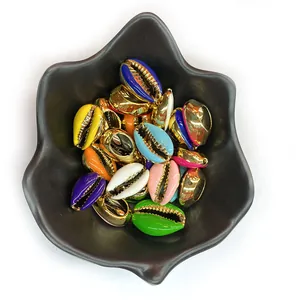 Colorful enamel seashell beads with gold edges for DIY jewelry making displayed in black tray