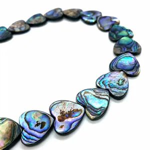 Macro shot of iridescent heart-shaped abalone shell beads for DIY jewelry making